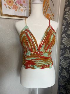 a white mannequin with a colorful top on it