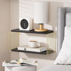 two shelves with books, a clock and a cup on top of each shelf next to a bed