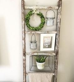 an old ladder is used as a shelf to display wreaths and other items on it