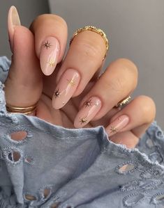 a woman's hand with some manies and gold stars on her nails,