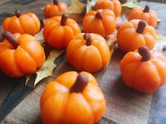 small orange pumpkins sitting on top of a table