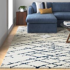 a living room with a blue couch and coffee table in front of a white wall