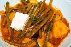 a bowl filled with green beans and potatoes