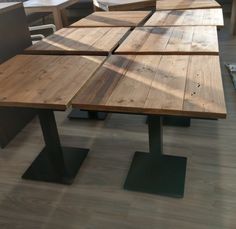 the table is made out of wood and has black metal legs on each side,