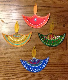 four colorful paper umbrellas sitting on top of a wooden table