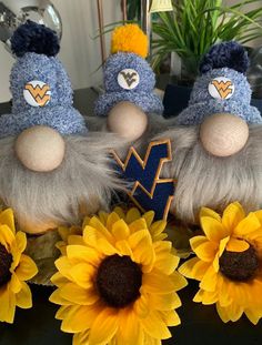 two stuffed animals sitting next to sunflowers on a table