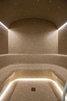 an indoor swimming pool with tiled walls and lights