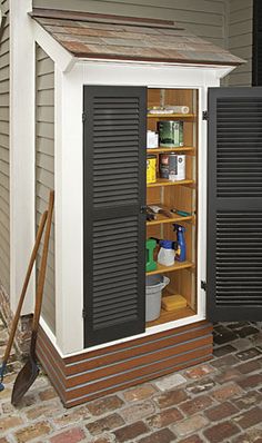 an outdoor storage shed with black shutters on the door and shelves full of cleaning supplies