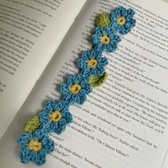 an open book with crocheted flowers on it