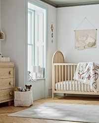 a baby's room with a crib and dresser