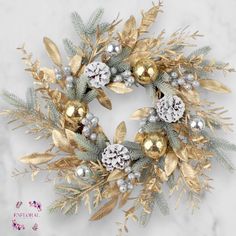 a gold and silver christmas wreath on a marble surface