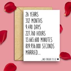 an anniversary card with the date and times printed on it, surrounded by red petals