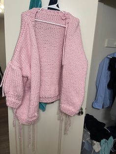 a pink sweater hanging on the wall