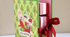 an open card box with christmas greetings on the front and sides, tied with a red ribbon