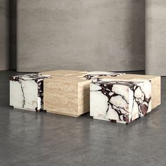 two marbled boxes sitting on top of each other in an empty room with concrete walls