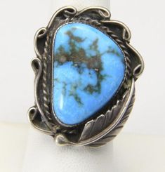 - Vintage Large Sterling Silver & Natural Blue Turquoise Leaf & Swirl Design Ring- Ring Size 8.5- Turquoise Stone measures 23mm tall by 17mm wide- Ring face measures 1.33" tall by 1.03" wide and .24" deep- Ring weighs 9.4 grams- Ring is lovingly crafted but unsigned- Very good vintage condition with some patina to sterling silver, we have not cleaned, and some surface scratching to silver band (see pics) Vintage Turquoise Ring, Figural Jewelry, Native American Design, Turquoise Jewelry Native American, Swirl Ring, Jewelry Turquoise, Wide Ring, Swirl Design, Vintage Turquoise