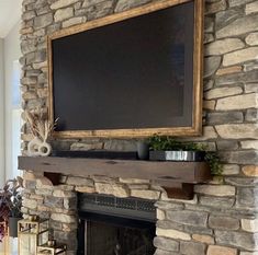 a stone fireplace with a chalkboard on the mantle