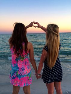 two girls standing on the beach with their hands in the shape of a heart and saying, if my sister in christ falls i fall