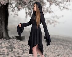 Step into an enchanting realm of style and sophistication with our meticulously crafted Black Hooded Witch Gothic Dress. Designed with a touch of dark allure and a dash of Renaissance inspiration, this dress is bound to make you the center of attention wherever you go. Here's why our dress deserves a place in your wardrobe: ✓ Unveil Your Elegance: Draped in the richness of black, this dress exudes an air of nobility that complements your personality. The captivating asymmetrical design, coupled Medieval Long Sleeve Halloween Dresses, Medieval Long Sleeve Dresses For Halloween, Gothic Long Sleeve Dress For Fantasy Events, Witchy Long Sleeve Cosplay Dress, Gothic Medieval Dress For Fall Costume Party, Medieval Dress For Fall Cosplay, Fitted Long Sleeve Medieval Dress For Halloween, Medieval Style Dress For Fall Cosplay, Black Gothic Dress For Fantasy Events