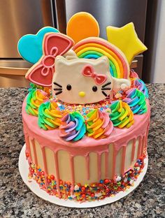 a hello kitty cake with rainbow icing and sprinkles on the top