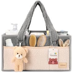 a teddy bear sitting next to a bag filled with personal care items on a white background