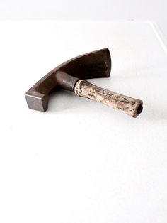 two hammers on top of a white surface with one being used as a tool