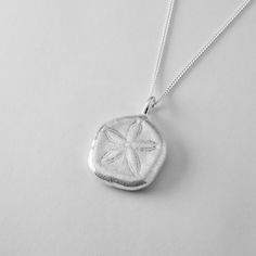 Step into summer with this radiant Sand Dollar Pendant. Inspired by the delicate skeletons of sand dollars, said in folklore to be the lost currency of mermaids, this pendant captures the ocean's charm. Unlike its fragile natural counterpart, this pendant will never crumble or tarnish, ensuring it remains a timeless keepsake. Perfect for casual outfits, resort wear, or adding a playful touch to date night, this necklace is a versatile addition to your collection. Each piece comes beautifully pac Sand Dollar Pendant, Sand Dollars, Jewelry Workshop, Sea Urchin, Sand Dollar, Sunshine Coast, Necklace Handmade, Sterling Silver Necklace, Queensland