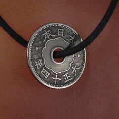 JAPANESE COIN charm necklace -circulated antique japanese coin from over 70 years ago -polished and clean coin -I have numerous of these coins in similar condition with slight variation in patina -you will receive a 24 inch adjustable black cord necklace ADD A CHAIN https://www.etsy.com/listing/96277094/chain-necklace-copper-brass-stainless?ref=v1_other_1 MORE COINS HERE http://www.etsy.com/shop/PartsForYou?section_id=7867468 MY OTHER SUPPLIES AND EARRING SHOP AT http://www.etsy.com/shop/CecileS Good Luck Coin-shaped Amulet Jewelry, Good Luck Coin Amulet Jewelry, Good Luck Coin Shaped Amulet Jewelry, Antique Medallion Jewelry For Good Luck, Vintage Coin Pendant Jewelry For Good Luck, Vintage Good Luck Coin Pendant Jewelry, Traditional Coin Shaped Good Luck Jewelry, Traditional Round Disc Jewelry As Gift, Adjustable Engraved Coin Jewelry