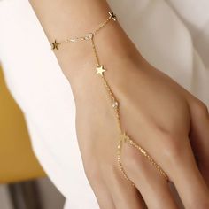 Revel in bohemian charm with our slave bracelet! Featuring shimmering zircon crystals and playful star accents, this unique accessory will have you shining like a star in no time. (Quirky and fun, without taking ourselves too seriously!) Metal: 925 sterling silver Finish: 18k gold Gemstone: white zirconia Bracelet length: adjustable with 4 cm extender (1.5") Chain: cable link Clasp: spring ring Hypoallergenic & nickel-free Don’t forget, proper care of your gold-plated jewelry will preserve its appearance for a long time. Keep it shining bright by using the soft side of the provided JFW polishing cloth Dainty Gold Alloy Chain Bracelet, Gold Resizable Jewelry For Party, Delicate Gold Body Jewelry For Gift, Gold Alloy Body Jewelry Gift, Gold Party Jewelry With Star Charm, Adjustable Gold Plated Chain Bracelet For Party, Gold Plated Crystal Bracelet For Party, Adjustable Clavicle Chain Body Jewelry Gift, Adjustable Delicate Jewelry With Star Charm