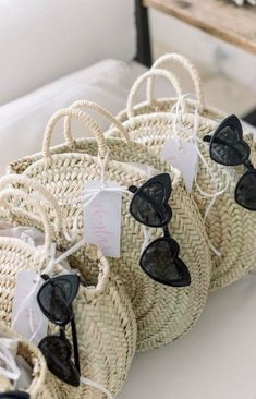 some straw bags with sunglasses on them sitting on a table