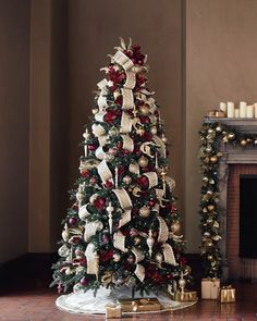 a decorated christmas tree in front of a fireplace