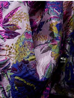 the fabric is very colorful and has flowers on it, as well as other things