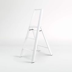 a white ladder leaning up against a white wall with no one on the top or bottom