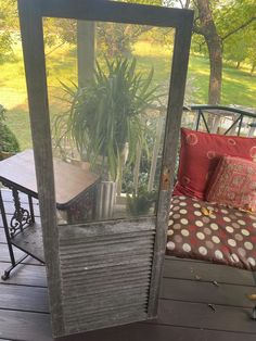 an open door to a porch with a couch and potted plant on the deck