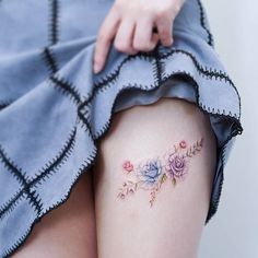 a close up of a woman's thigh with flowers on it