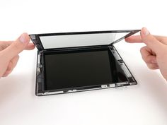 two hands are holding up the screen to separate it from the rest of the device