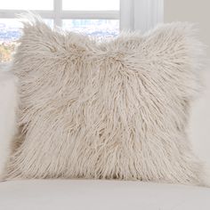 a fluffy white pillow sitting on top of a couch