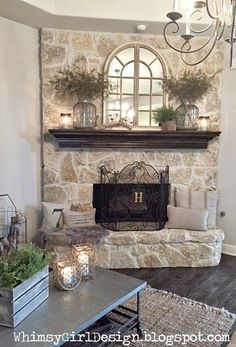 a living room with a stone fireplace and lots of plants on top of the mantle