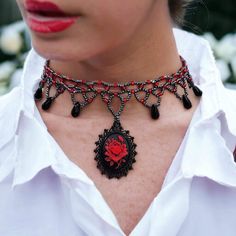 "Here is a choker that is truly captivating - a masterpiece that effortlessly combines the vintage allure of yesteryears with a touch of modern elegance. Behold, the centerpiece of this conversation: a Gothic-style choker that beckons with its unique charm. Picture a red rose, vivid and striking, set against an enigmatic black background, forming an intricate cameo. This captivating piece is cradled within a gunmetal setting, designed to mesmerize anyone who sets their gaze upon it. What sets th Red Choker Necklaces For Formal Occasions, Red Choker Necklace For Formal Occasions, Vintage Beaded Choker As A Gift, Vintage Choker As Valentine's Day Gift, Formal Red Choker Necklace, Vintage Beaded Choker As Gift, Formal Red Choker Necklaces, Elegant Rose Design Jewelry Choker, Vintage Beaded Jewelry For Valentine's Day