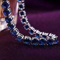 A classic tennis bracelet with a colorful surprise. 28 of the highest quality Sapphire Blue Swiss CZ diamonds in a solitaire pattern. The setting is triple platinum clad (highest quality platinum plating) and each stone is prong-set for security. Snap hook closure for comfort and security. Flexible for comfort--can be worn all day! Swiss CZs are known for their sparkling reflection of light with deep colors. Very versatile can be worn every day or for a special occasion. Coordinates well with yo Party Blue Brilliant Cut Jewelry, Sapphire Cubic Zirconia Tennis Bracelet, Sapphire Cubic Zirconia Tennis Bracelet With Gemstone, Crystal Round Tennis Bracelet For Party, Crystal Tennis Bracelet For Parties, Sapphire Diamond Tennis Bracelet Gift, Silver Sapphire Tennis Bracelet With Brilliant Cut, Silver Sapphire Tennis Bracelet, Silver Party Tennis Bracelet With Prong Setting