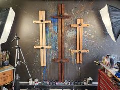 an art studio with multiple wooden crosses on the wall