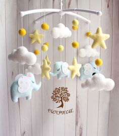 a baby mobile with elephants and stars hanging from it