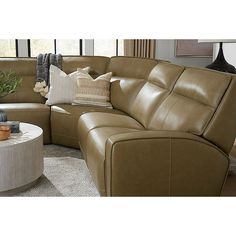 a living room with a sectional couch and round coffee table