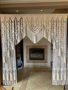 a living room with a fireplace and white curtains