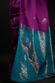 Get ready to turn heads with this stunning silk saree! The beautiful purple and azure blue color combination of this Silk saree will make a strong statement no matter where you go. Intricate gold embroidery work along the pallu adds a bit of traditional flair that makes this saree perfect for special occasions. Whether you're attending a wedding or hitting up an office party, this classic yet eye-catching look is sure to make your mark on any setting. Plus, you'll stay comfortable since the lush fabric of silk wraps around you like second skin. Make an unforgettable impression with this regal and unique ensemble! Purple Art Silk Pre-draped Saree With Self Design, Bollywood Style Purple Handloom Pre-draped Saree, Purple Katan Silk Pre-draped Saree With Zari Work, Blue Chanderi Pre-draped Saree With Motifs, Traditional Purple Tissue Silk Pre-draped Saree, Purple Paithani Silk Pre-draped Saree For Wedding, Blue Silk Pre-draped Saree For Traditional Ceremonies, Purple Katan Silk Pre-draped Saree With Cutdana, Purple Pre-draped Saree With Cutdana For Traditional Ceremonies