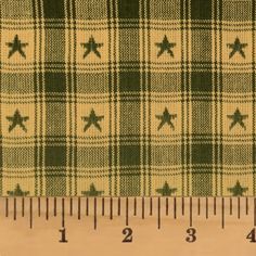 a ruler is next to a green and white checkered fabric with stars on it