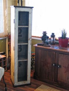 an old metal cabinet sitting in the corner of a living room next to a window