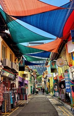 an alley with many colorful umbrellas hanging from it's sides