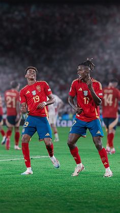 two soccer players in red and blue uniforms are on the field with their hands together