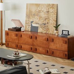 a living room scene with focus on the coffee table and large painting in the background